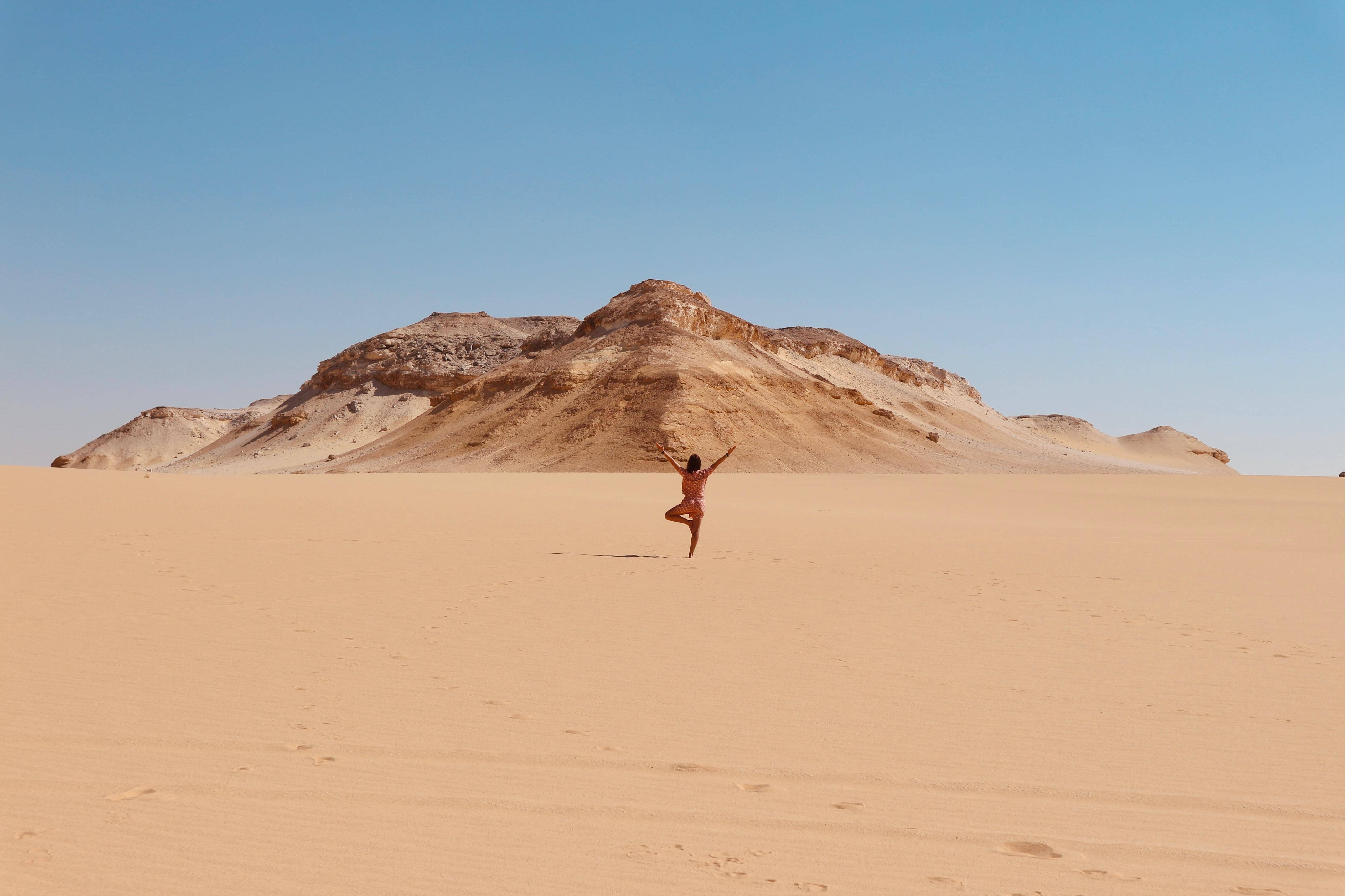 Viajera en el desierto egipcio con montañas al fondo