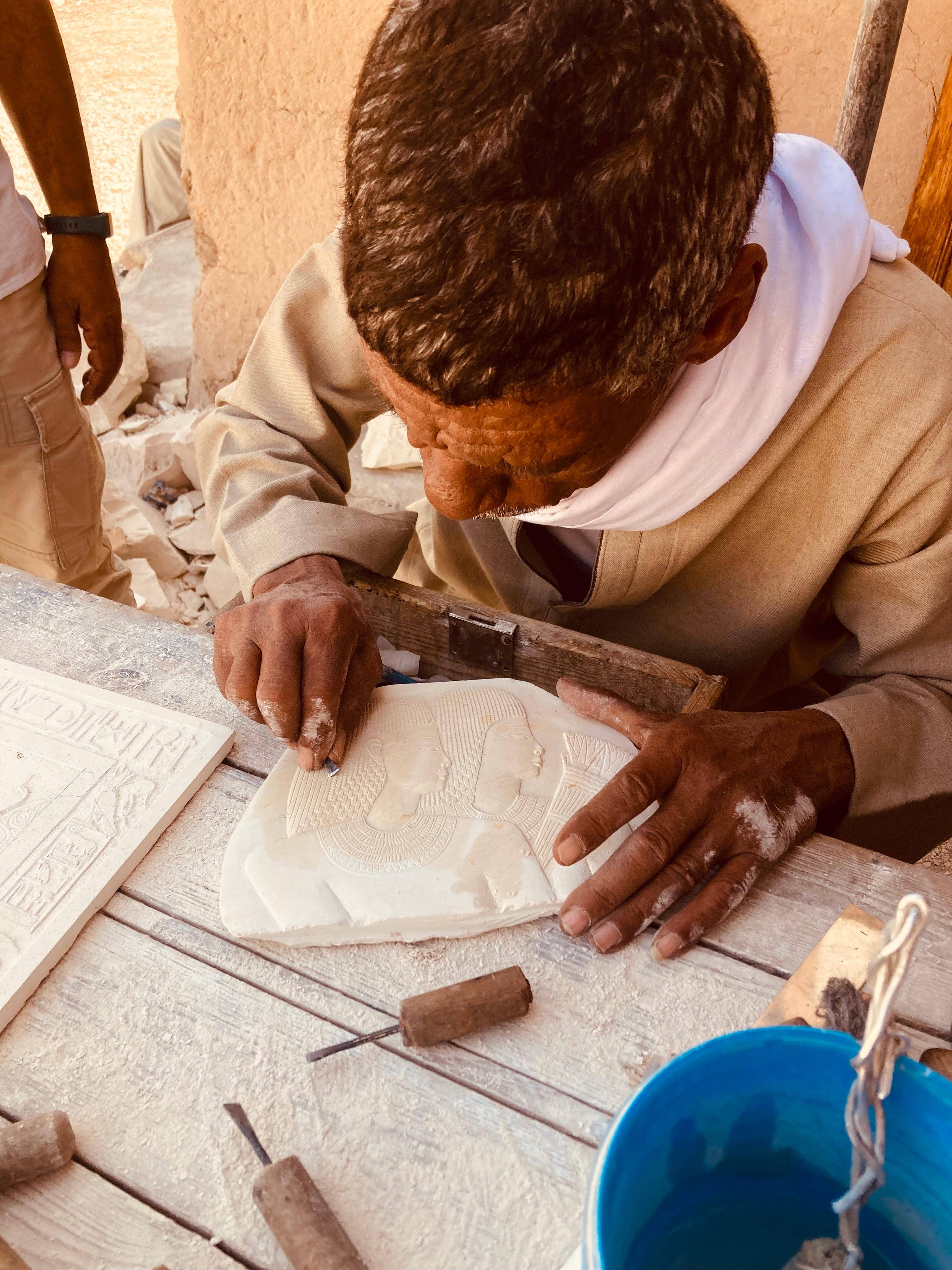 Artesano tallando jeroglíficos en piedra