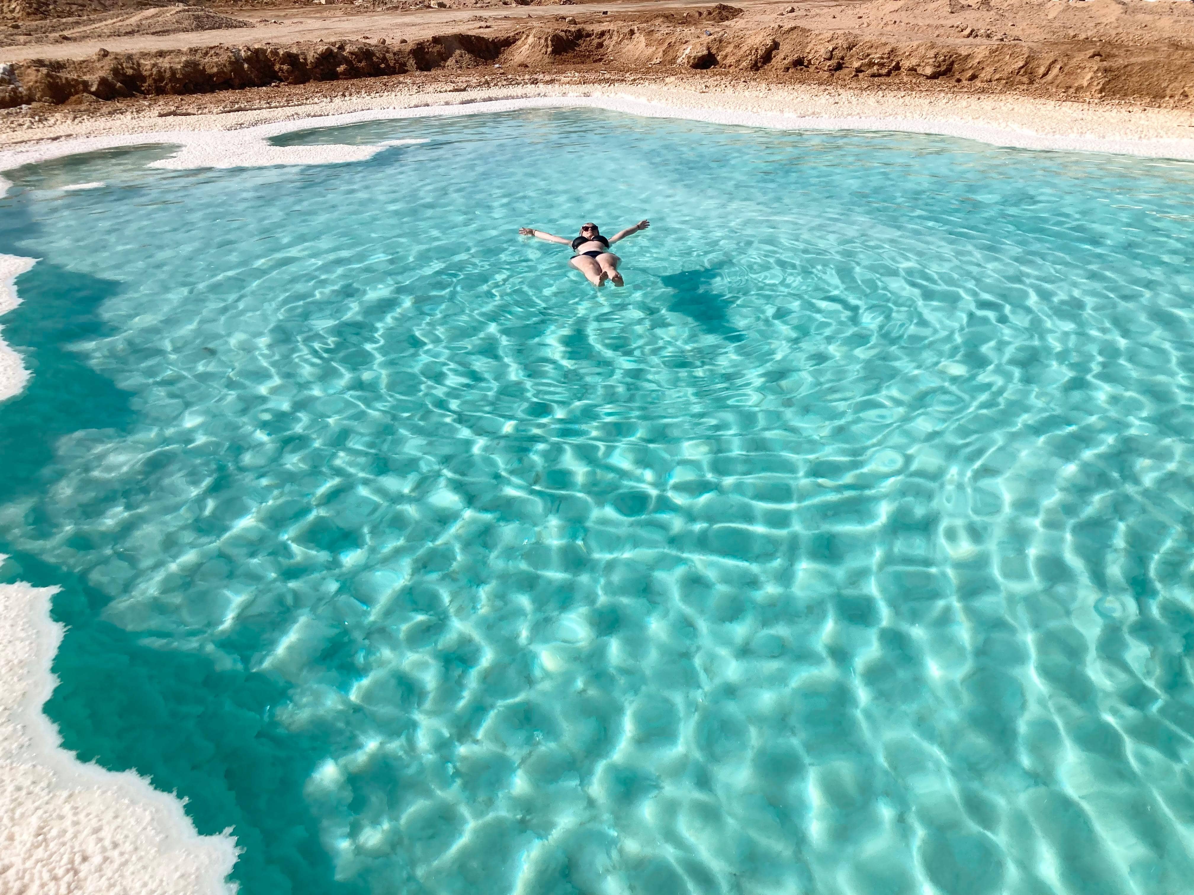 Viajera flotando en aguas turquesa del oasis de Siwa