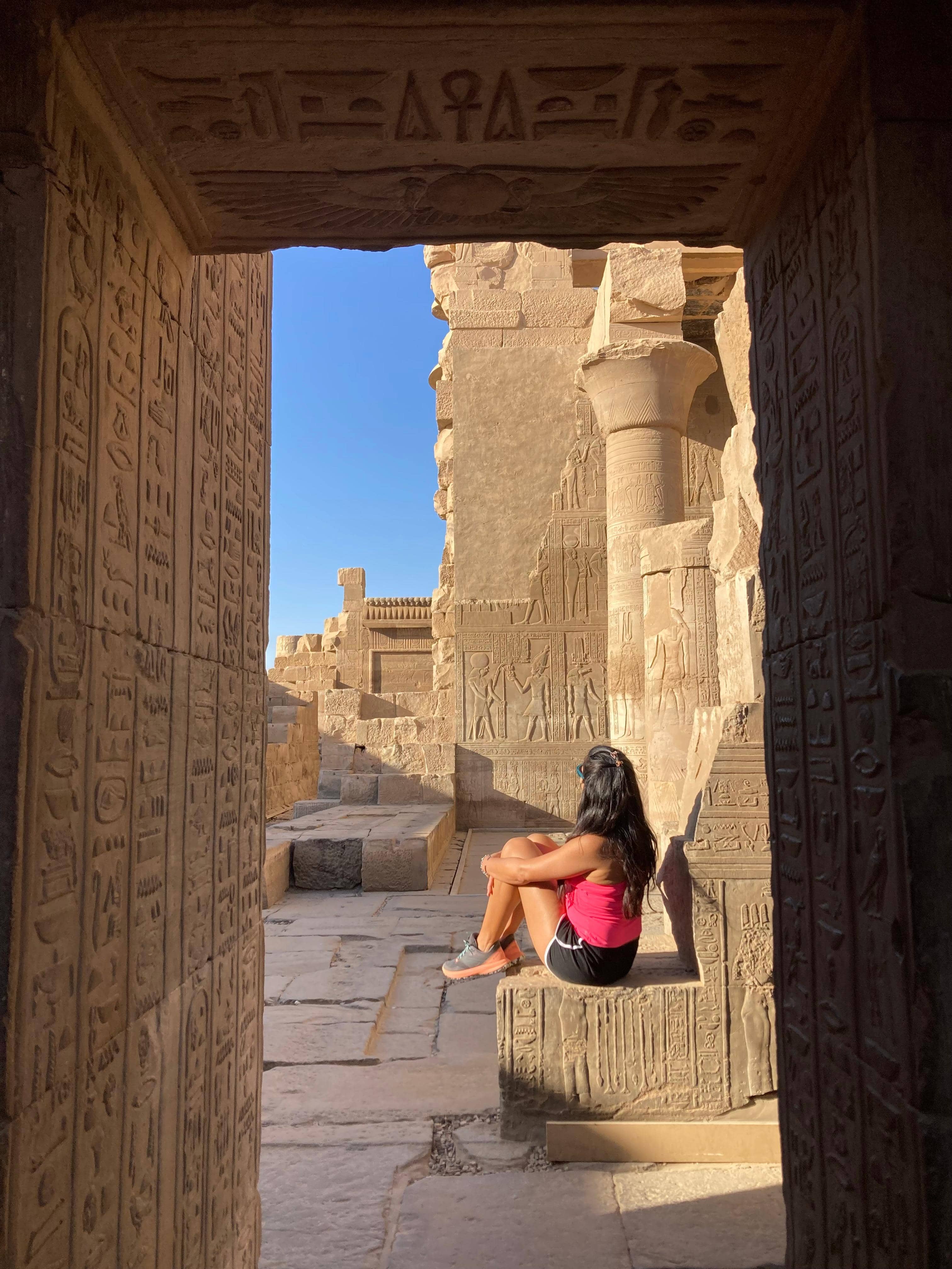 Viajera contemplando jeroglíficos en templo egipcio